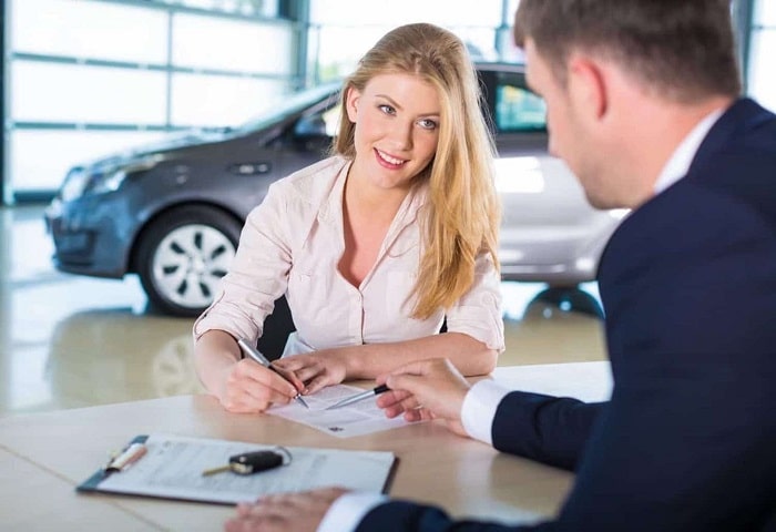 5 Benefits of Buying From A Dealership Vs. A Private Seller in Saskatoon Middle Aged woman looks at financing options at Guest Auto Sales